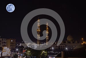 A full moon over the Al Mina Mosque at night in the city of Hurghada