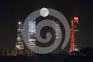 Full moon over Cuatro Torres business area skyline at night in Madrid, Spain. photo