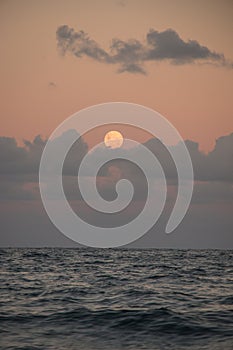 Full moon over ocean and clouds