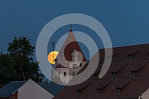 Full moon over the roofs and towers of Regensburg, Germany