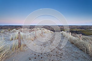 Full moon over sand path in dunes