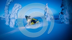 Full moon over snowy mountains as snowmobile carves through