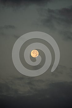 Full moon photo with some clouds during blue hour