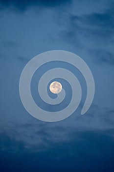 Full moon photo with some clouds during blue hour