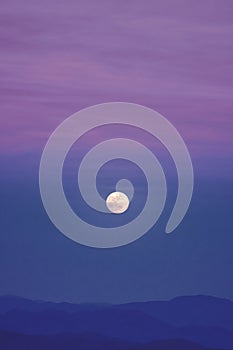 A full moon in a purple sky