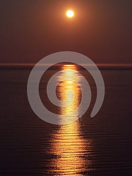 Full moon reflecting in the calm sea at night time