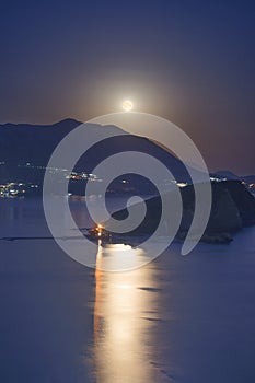 Full moon rise above Budva Riviera, Saint Nicholas island and Adriatic littoral, night cityscape, Montenegro, Europe. Famous