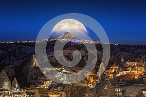 Full moon rising above Uchisar castle in Cappadocia, Turkey