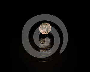 Full Moon Rising Over Calm Sea with reflection on water