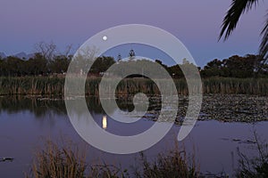 A full moon rising over a dam in Worcester, showing reflected light beams