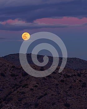 Full Moon Rising Over Desert Mountains