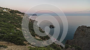 Full moon rising over sea bay and mountains. Flying clouds in the night sky over sea and cliffs on full moon background