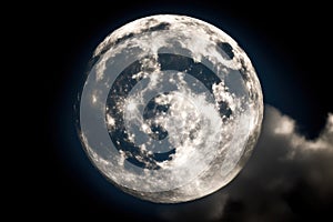 a full moon is seen through the clouds in the night sky