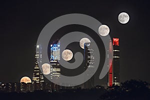 Full moon sequence over Cuatro Torres business area skyline at night in Madrid, Spain. photo