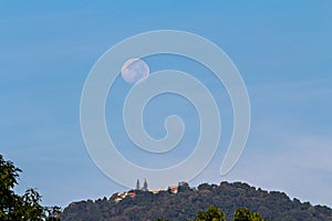 Full moon setting over Buddhist temple