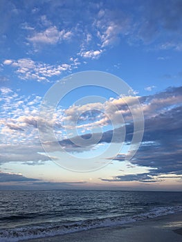 Full Moon Setting during Sunrise on July 4th at Beach in Far Rockaway in New York, NY.