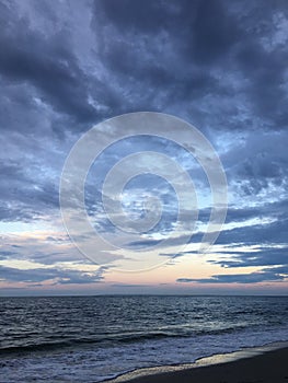 Full Moon Setting during Sunrise on July 4th at Beach in Far Rockaway in New York, NY.