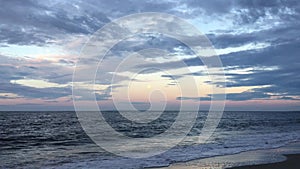 Full Moon Setting during Sunrise on July 4th at Beach in Far Rockaway in New York, NY.