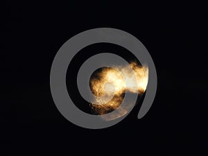 Full moon shining through clouds at night