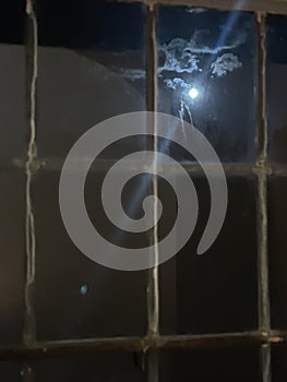 Full moon shining in night sky through old fashioned window