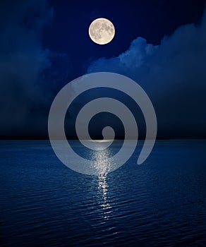 full moon in sky over clouds and water in river