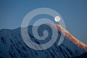 Full moon during a sunrise on the background of snow-capped in Himalayas mountains in Nepal