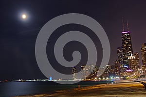 Full moon in violet colored sky with view of Chicago skyline along Lake Michigan