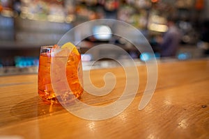 Full orange spritz cocktail drink sitting on bar counter