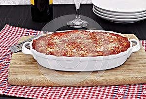 Full oval white baking pan of baked eggplant or lasagna.