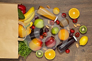 Full paper bag of different health food on wooden background, close up. Grocery shopping concept.