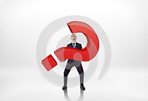 Full portrait of a businessman holding big red 3d question mark isolated on white background