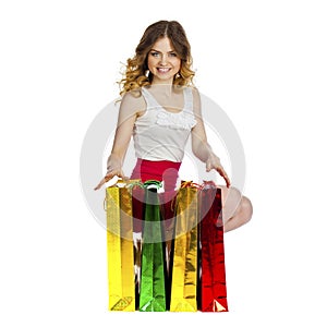 Full portrait of smiling young blonde girl with colorful shoppin