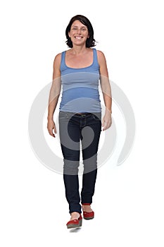 Full portrait of a woman walking and with casual clothes on white background, front view
