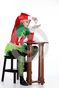 Full portrait of young girl wearing red santa clause hat question look with empty milk