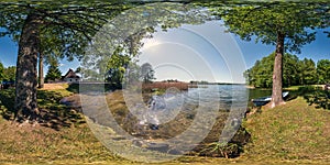 Full seamless panorama 360 by 180 angle view on the shore of huge forest lake with a boat in sunny summer day in equirectangular