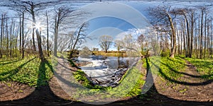 Full seamless spherical 360 hdri panorama view in beautiful spring forest or park with bright sun shining through the trees near