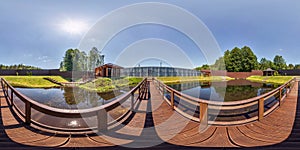 Full seamless spherical hdr 360 panorama on wooden pedestrian bridge over lake near vacation home in equirectangular projection