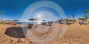 Full seamless spherical hdr 360 panorama view on coast of sea with wooden beach umbrellas and sun loungers by red sea in bright photo