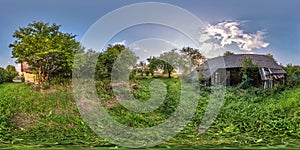 Full seamless spherical hdri panorama 360 degrees angle view near abandoned overgrown with bushes wooden house in village in