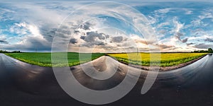 Full seamless spherical hdri panorama 360 degrees angle view on wet asphalt road among canola fields in evening sunset after storm