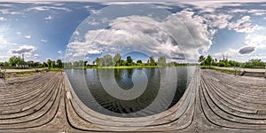 Full seamless spherical hdri panorama 360 degrees  angle view on wooden pier of lake or rivere with beautiful clouds in