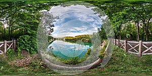 Full seamless spherical hdri panorama 360 degrees angle view on limestone coast of huge green lake or river near forest in summer