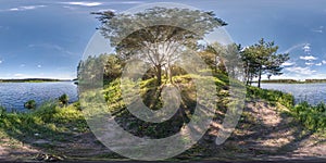 Full seamless spherical hdri panorama 360 degrees angle view near huge tree on banks of wide river with rays of sun through