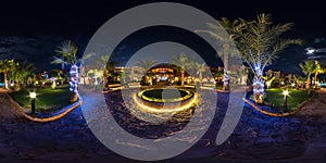 Full seamless spherical night hdr 360 panorama on territory of elite hotel with palm trees and neon  lights in desert on shores of photo