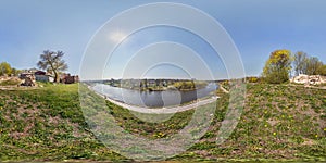 Full seamless spherical panorama 360 degrees angle view on bank of wide river in front of bridge near ancient destroed castle in