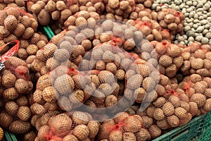 Full shelfs with potato in supermarket.