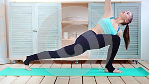 Full shot fit yoga woman practicing pose dog muzzle down on mat at home side view