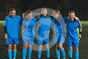 full shot of five members of school girls football team in a stadium having practice, team work in football