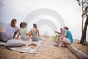 Full size back photo of nice young ladies guys sit wear casual cloth ouside by the sea picnic
