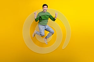 Full size body photo of jump trampoline crazy guy fingers showing rock roll punk gesturing singing isolated on yellow